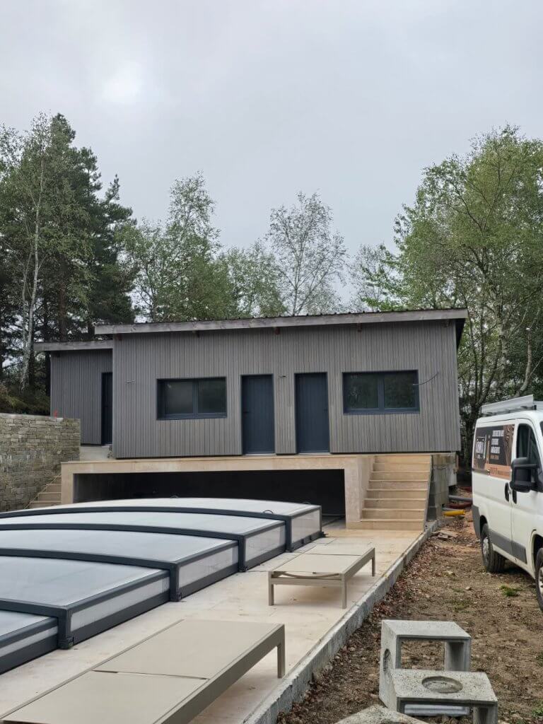 chalet vue de face à la fin de son chantier de rénauvation de sa façade par un bardage en bois.